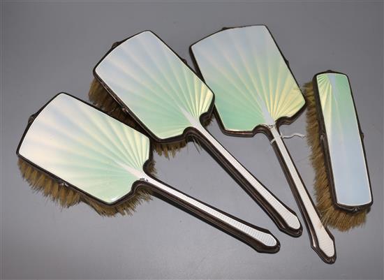 A four piece silver and enamel dressing table set.